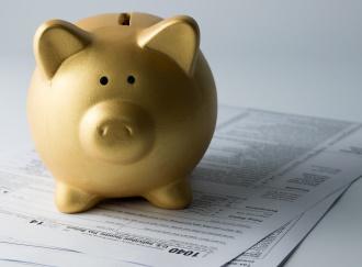 Golden Piggy Bank Atop Tax Forms