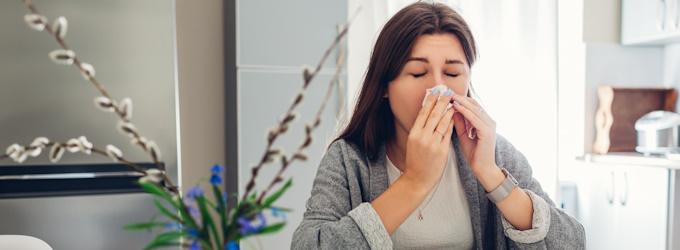 woman sneezing with spring allergies