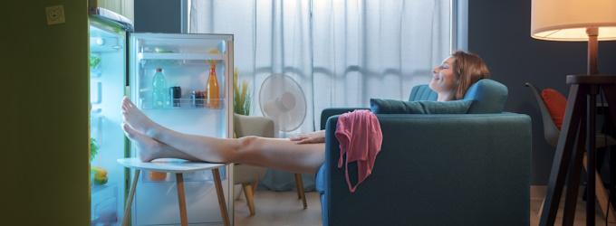 woman cooling off in front of fridge