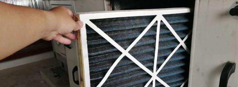 Person replacing a dirty HVAC air filter to maintain system performance and indoor air quality.