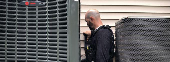 Meyer Heating & Air owner performing hands-on HVAC repair on an outdoor unit at a St. Louis home.