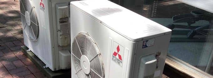 Mitsubishi Electric ductless mini-split outdoor heat pump units installed on ground pads by Meyer Heating & Air.