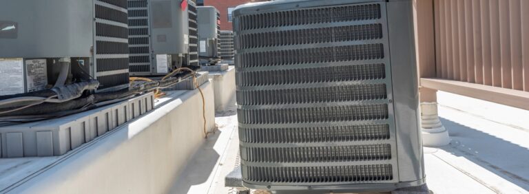 Commercial HVAC heat pump units on a rooftop, representing systems that may show signs of wear, failure, or need for replacement.