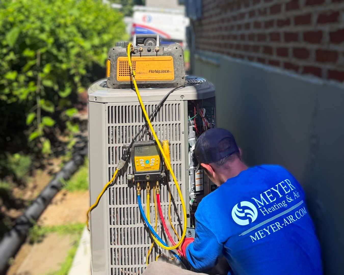 Meyer Heating & Air technician servicing an outdoor system