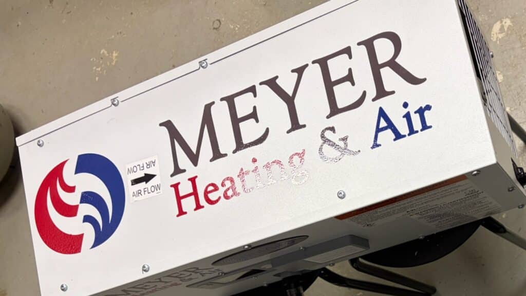Close-up of a white whole-house dehumidifier unit featuring the Meyer Heating & Air company logo.