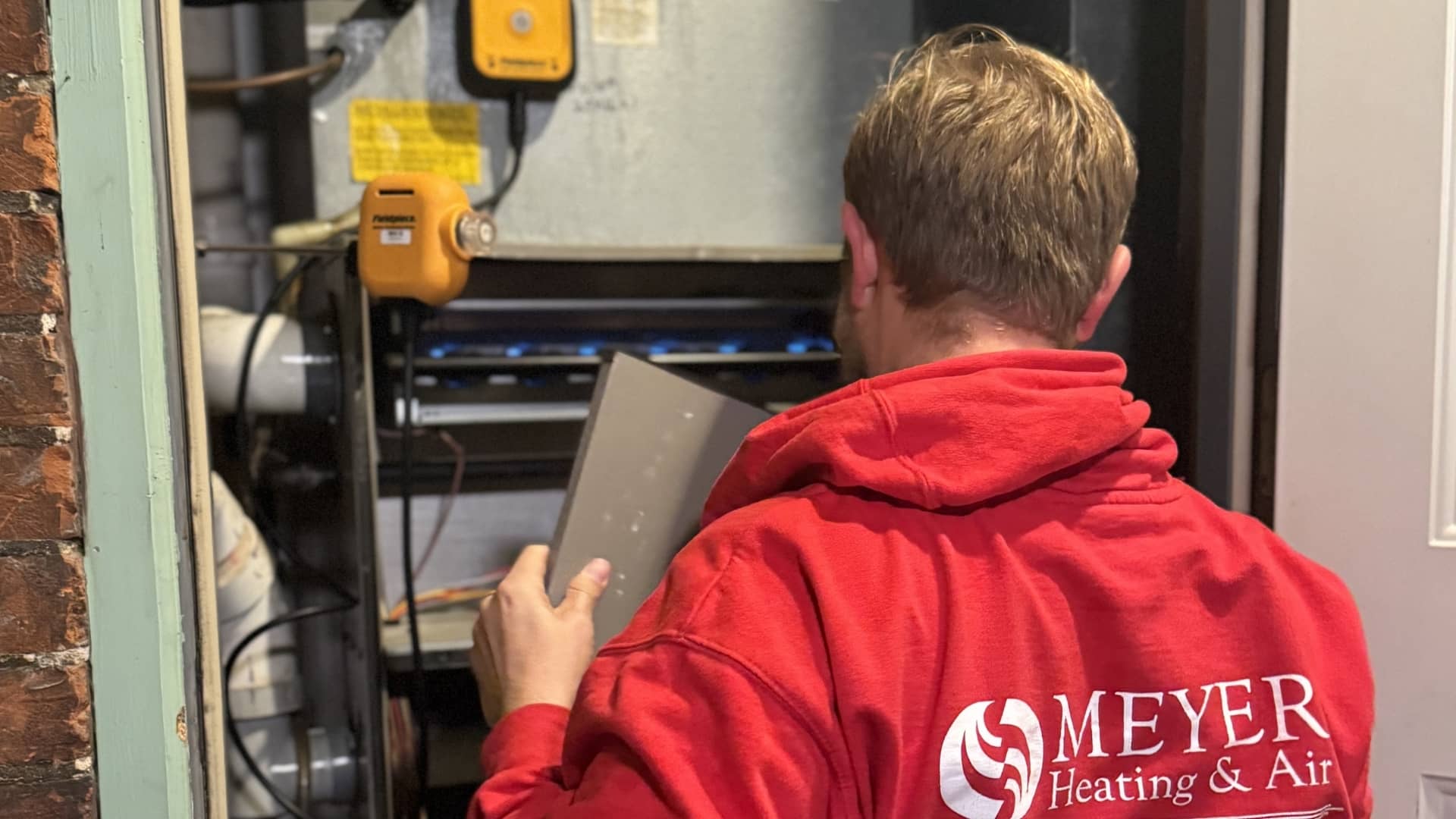 Meyer Heating & Air technician servicing a furnace