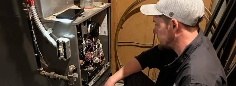 Meyer Heating & Air technician diagnosing internal wiring and condensate drain issues on a leaking residential gas furnace.